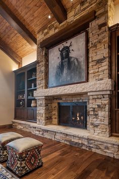 a living room with stone fireplace and built in bookshelves