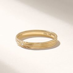 a close up of a gold ring on a white surface with the words dia air written on it