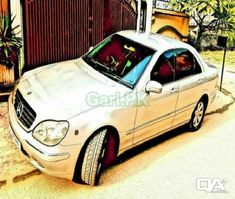 a white car parked in front of a gate