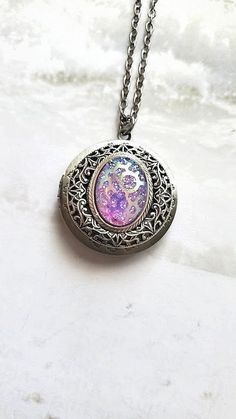 Rainbow Aura Pendant Locket Necklace The locket is set with silver adornment framing a rainbow multi color aura style center. Colors appear in the center stone as Purple, Pink and aqua. ~ See Photos for size comparison against American quarter Chain: ~ Silver Plated YOU CHOOSE YOUR CHAIN LENGTH during checkout ☻More Lockets Here: https://www.etsy.com/shop/FashionCrashJewelry/search?search_query=lockets&order=date_desc&view_type=gallery&ref=shop_search ☻Link to The ENTIRE SHOP: https://www.etsy.c Unique Rainbow Jewelry For Gifts, Mystical Multicolor Jewelry For Gift, Bohemian Iridescent Jewelry As A Gift, Bohemian Iridescent Jewelry For Gifts, Handmade Mystical Multicolor Jewelry, Bohemian Silver Keepsake Jewelry, Spiritual Rainbow Jewelry For Gifting, Iridescent Gemstone Jewelry With Magical Style, Spiritual Rainbow Jewelry For Gifts