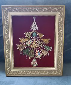 a christmas tree made out of beads in a gold frame