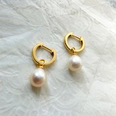 OUR*SPECIAL*ITEM Dainty gold hoops with a tiny pearl, These simple, delicate and versatil earrings that you can wear at any occassion. Confortable to use and wear, is the perfect outfit for your day. You can combinate with other dainty studs or hoops at the same ear. DETAILS *Material: High Quality solid 925 sterling silver plated in 18k gold, natural pearl. *Dimensions: Diameter of the hoops 12mm, Pearl : 10*8mm * Sold in pairs. *All our items are nicely packaged ready to gift in elegant jewelr Everyday Small Hoop Huggie Earrings With Pearl Drop, Small Hoop Huggie Earrings With Pearl Drop, Gold Minimalist Huggie Earrings With Pearl Drop, Everyday Small Huggie Earrings With Pearl Drop, Dainty Everyday Pearl Drop Huggie Earrings, Pearl Charm Huggie Earrings, Everyday Small Hoop Earrings With Pearl Chain, Everyday Huggie Earrings With Pearl Charm, Dainty Huggie Earrings With Pearl Charm For Everyday