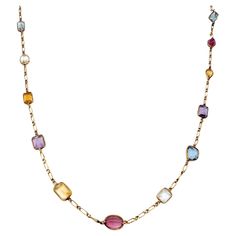 Long, luxurious multi-gemstone station necklace bursting with color. This amazing piece absolutely lights up the neck! Featuring 21 assorted bezel set gemstones on an elongated link chain, the colorful stones pop against the warm yellow gold setting. Shades of pink, blue, purple, yellow, orange and green radiate throughout the piece, each a different shape and hue. This necklace can be dressed up or down and adds the perfect pop of color to your look. The long piece can also be wrapped around th Asymmetrical Jewelry, Multi Gemstone Necklace, Purple Yellow Orange, Colored Necklace, Colorful Stones, Bezel Necklace, Gold Long Necklace, Gem Necklace, Warm Yellow