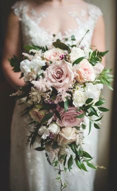 a bridal holding a bouquet of pink and white flowers