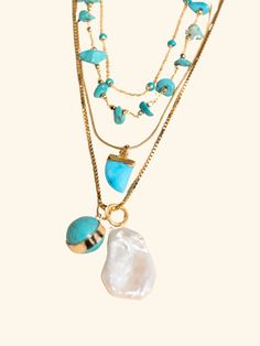 Picture a sunny day by the beach, where the gentle salty breeze and warmth of the sun kisses your skin. This turquoise and gold necklace stack embodies the essence of summer, capturing the vibrant energy and carefree spirit of the season. The Stack Includes: #1 Top Necklace - The Turquoise Dot Choker It is 14 inches. The warm, golden tones of the chains complement the cool hues of the turquoise, creating a striking contrast that embodies the playful elegance of summer. #2 Middle Necklace - The T Ocean-inspired Turquoise Necklaces For Vacation, Turquoise Ocean-inspired Necklaces For Vacation, Turquoise Ocean-inspired Necklace For Vacation, Handmade Gold Turquoise Necklace For Beach, Bohemian Gold Turquoise Necklace For Beach, Bohemian Turquoise Necklace For Beach, Bohemian Multi-strand Turquoise Necklace For Beach, Bohemian Turquoise Necklaces For Layering, Turquoise Bohemian Necklace For Vacation