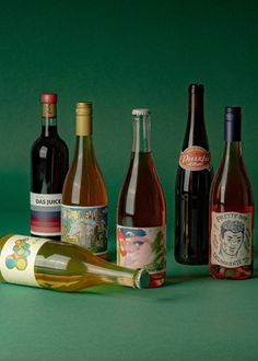 several different types of wine bottles on a green surface