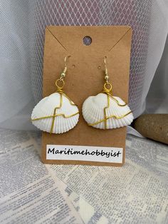 These simple yet elegant earrings are made from seashells wrapped in gold plated wire and hung on gold plated earring hooks which are hypoallergenic! They come with rubber backings for securing your earrings in place. They make the perfect addition to any summer outfit and any beach day! Orders within Canada are sent via oversized lettermail (no tracking) to keep shipping costs low. Tracking is available at the checkout for an extra fee.  Orders to the US are sent via tracked packet USA air. Elegant Beach Earrings With Wire Wrapped, Elegant Wire Wrapped Earrings For Beach, Handmade Gold Shell-shaped Earrings, Handmade Gold Shell Earrings, Handmade Gold Dangle Shell, Hand Wrapped Gold Drop Earrings, Gold Hand Wrapped Drop Earrings, Gold Shell Ear Wire Gift, Wire Wrapped Drop Earrings For Beach