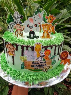 a birthday cake decorated with jungle animals and zebras