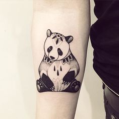 a black and white panda bear tattoo on the arm