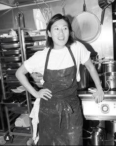 a woman in an apron standing next to a stove