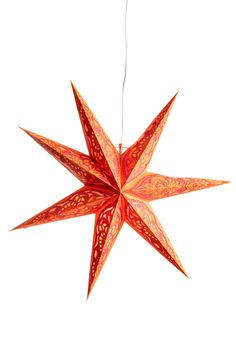 an ornament shaped like a star hanging from a string on a white background