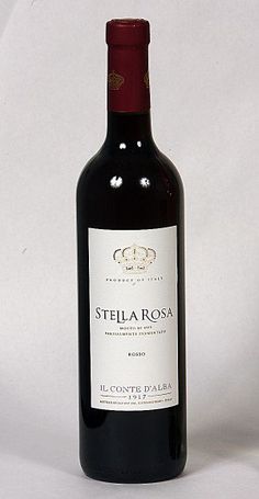 a bottle of red wine sitting on top of a white table