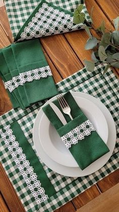 a place setting with green napkins and white plates