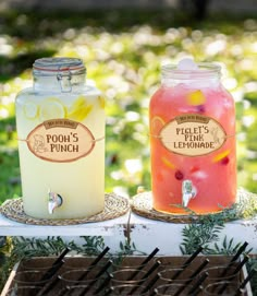 two jars filled with drinks sitting on top of a table