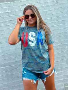 Celebrate the Fourth of July in style with this fun and cute USA Green Camo T-Shirt! Show off your patriotism with this comfy short sleeve camo shirt with red, white, and blue USA design. Perfect for everyday wear, this t-shirt adds a sense of fun and celebration to any look! Unisex sizing and fit Patriotic Flag Print Top For Veterans Day, Patriotic Tops With Flag Print For Veterans Day, Casual Tops With American Flag For Veterans Day, Casual American Flag Tops For Veterans Day, Veterans Day American Flag Short Sleeve Top, Blue American Style Short Sleeve T-shirt, Blue Short Sleeve American Style T-shirt, American Style Made In Usa Short Sleeve Top, Blue American Flag T-shirt