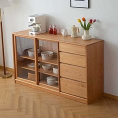 a wooden cabinet with dishes and cups on it