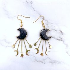 Dance with the Stars: Black & Gold Moon Wire Hook Earrings (Gift for Her) ✨Embrace the celestial spirit with these enchanting Black & Gold Moon Wire Hook Earrings! A captivating addition to your jewelry collection, this pair features a pair of black crescent moons adorned with shimmering gold accents.A perfect gift for the mystical woman in your life, these earrings embody the beauty and intrigue of the night sky. The lightweight design and comfortable hook closure with push backs ensure comfort Adjustable Black Crescent Earrings, Black Celestial Earrings For Gift, Celestial Black Metal Jewelry, Black Drop Earrings With Moon Charm, Mystical Black Metal Earrings, Whimsical Black Earrings With Ear Wire, Nickel-free Black Crescent Earrings, Black Moon Shaped Earrings For Gift, Black Moon-shaped Earrings For Gift