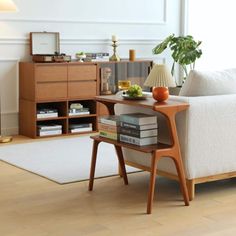 a living room with a white couch and wooden table next to bookshelves on the floor