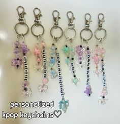 several key chains with charms attached to them on a white surface and the words personalized kpop keuchains written below