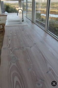 the kitchen counter is made out of wood and has glass doors to let in natural light