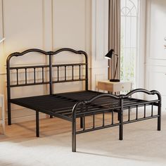 a black metal bed frame in a white room