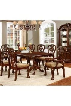 a dining room table with chairs and a rug