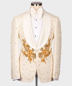 a white tuxedo with gold sequins and flowers on the lapel