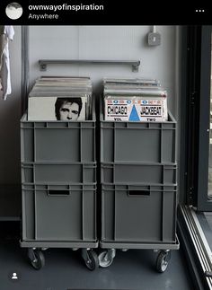 there are three bins with magazines in them on the floor next to a window