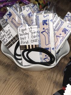 a bowl filled with lots of different items on top of a wooden table next to scissors