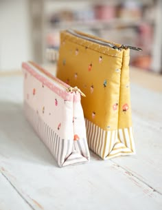 two small zippered pouches sitting on top of a table