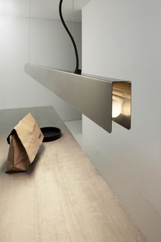 a bag sitting on the ground next to a light fixture in a room with white walls