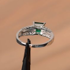 It is a lab emerald ring. The main stone is 6 mm*6 mm princess cut.weight about 0.93 carats. The basic metal is sterling silver and plated with rhodium. To change the metal to a solid gold (white/rose) or platinum is also available, please ask for a quotation if you want. You can also go to my shop Home for more elegant rings: https://www.etsy.com/shop/godjewelry?ref=hdr_shop_menu Emerald is the May birthstone More emerald rings: https://www.etsy.com/shop/godjewelry?section_id=20709240 Customiza Princess Cut Emerald Jewelry, Silver Emerald Ring With Princess Cut And Prong Setting, Silver Princess Cut Emerald Ring With Prong Setting, White Gold Cubic Zirconia Emerald Ring Princess Cut, Princess Cut Emerald Promise Ring, Silver Princess Cut Emerald Ring For May Birthstone, Silver Emerald Ring With Princess Cut, Princess Cut Silver Emerald Ring For May Birthstone, Cubic Zirconia Emerald Ring With Princess Cut