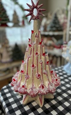 a glass christmas tree sitting on top of a black and white checkered table cloth