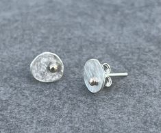 These Silver Pebble studs have a brushed finish and shiny 9ct gold dot detail. They are made from Argentium silver which has more pure silver in it than Sterling silver so does not tarnish over time and has no need to be regularly cleaned with a silver cloth. These studs are very light weight and are an irregular/oval shape measuring approximately: 9 x 7mm in size. I'd you would like a different size please message me. The posts are also Argentium silver and the push backs are Sterling silver. Metal Jewelry Making, Minimalist Studs, Gold Dots, Argentium Silver, Gold Studs, Silver Studs, Pure Silver, Metal Jewelry, Jewelry Earrings Studs