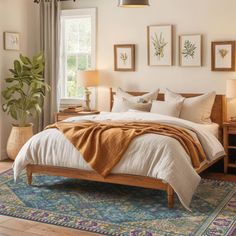 a bedroom with a bed, nightstands and pictures hanging on the wall above it