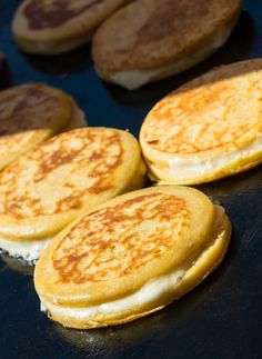 four pancakes sitting on top of a pan covered in cheese