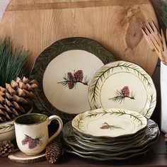 a table topped with plates and cups filled with pineconis on top of a wooden shelf