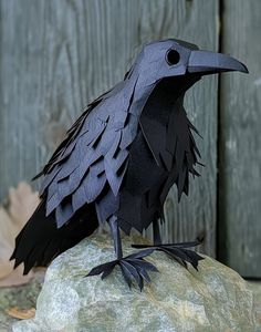 a paper bird sitting on top of a rock