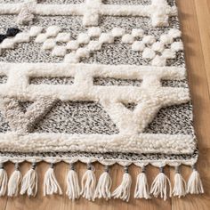 a white rug with tassels on top of it