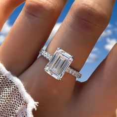 a woman's hand with a ring on it and an emerald stone in the middle