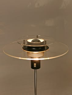 a lamp that is on top of a glass table with a light in the middle