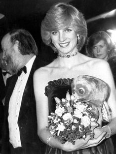 an old photo of a woman in a dress with flowers on her chest and necklace