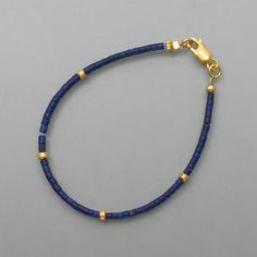 This lapis lazuli bracelet has a classic design throughout. Small rolls of lapis lazuli line up and are interrupted at regular intervals by similarly shaped gold-plated silver parts. The intense and dull blue of the lapis lazuli and the warm color of the gold combine to form a wonderfully uncomplicated and stylish bracelet. Here you will find the matching necklace or matching earrings Dimensions: Diameter of the rollers: 2 mm, length: 19 cm Gold Lapis Lazuli Beaded Bracelets With Round Beads, Gold Bracelets With Lapis Lazuli And Natural Stones, Hand-strung Gold Lapis Lazuli Bracelets, Gold Beaded Lapis Lazuli Bracelets, Blue Gemstone Beads Minimalist Bracelets, Minimalist Blue Gemstone Bead Bracelets, Dull Blue, Lapis Lazuli Bracelet, Stylish Bracelet