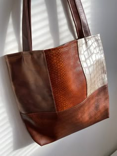 a brown and white purse hanging on a wall