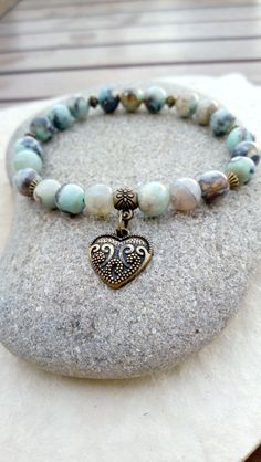 A gentle energy emanates from this "Connection" bracelet in aqua terra jasper. It will help you keep a positive state of mind, regain hope if you no longer have any, it will bring you peace, harmony and a feeling of compassion for others and for yourself. Composed of 21 aqua terra jasper beads, decorated with small bronze-colored metal beads and a pretty heart-shaped "love" medal. Dimensions: approximately 18 cm (can be adjusted on request, other sizes possible on order) Because you are unique, Release Negative Energy, Compassion For Others, Releasing Negative Energy, Pretty Heart, Aqua Terra, Jasper Beads, First Name, State Of Mind, Bronze Color