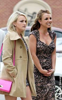 two women walking down the street with one carrying a pink purse and another holding a pink handbag