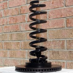 a large metal object on top of a table next to a brick wall