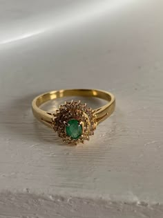 k18 gold ring 2.2 grams emerald gem stone 0.21 carat diamond around the gem stone is 0.17 carat size 10.5 This is a preloved ring. Been using it for a few years now. Design Of Rings Gold, Year Rings Gold, Indian Gold Stone Rings, Indian Traditional Stone Rings, Indian Rings Gold, Traditional Gold Ring, Green Stone Gold Ring, Green Stone Ring For Women, Gold Ring With Stone