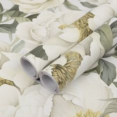 a white flowered wallpaper with green leaves and flowers on the background is an image of two rolls of toilet paper