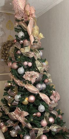 a christmas tree decorated with pink and gold ornaments